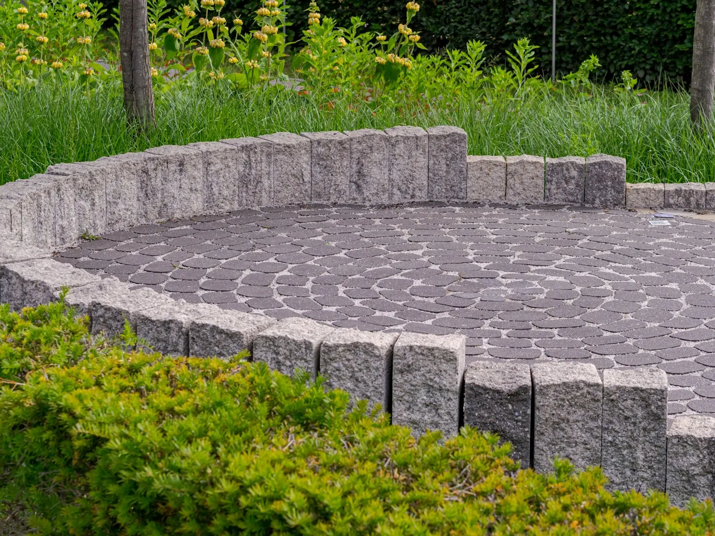 A circular paved patio edged with a low stone wall